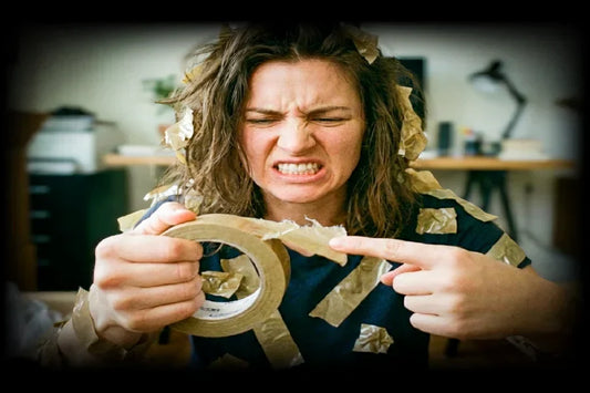 Frustrated woman trying to find the end of a packing tape