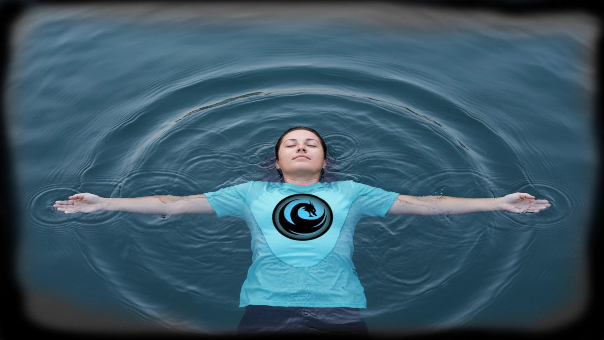 Woman floating peacefully in water wearing WaterDragon inspirational graphic tee with ripples spreading outward symbolizing positive self-care apparel.
