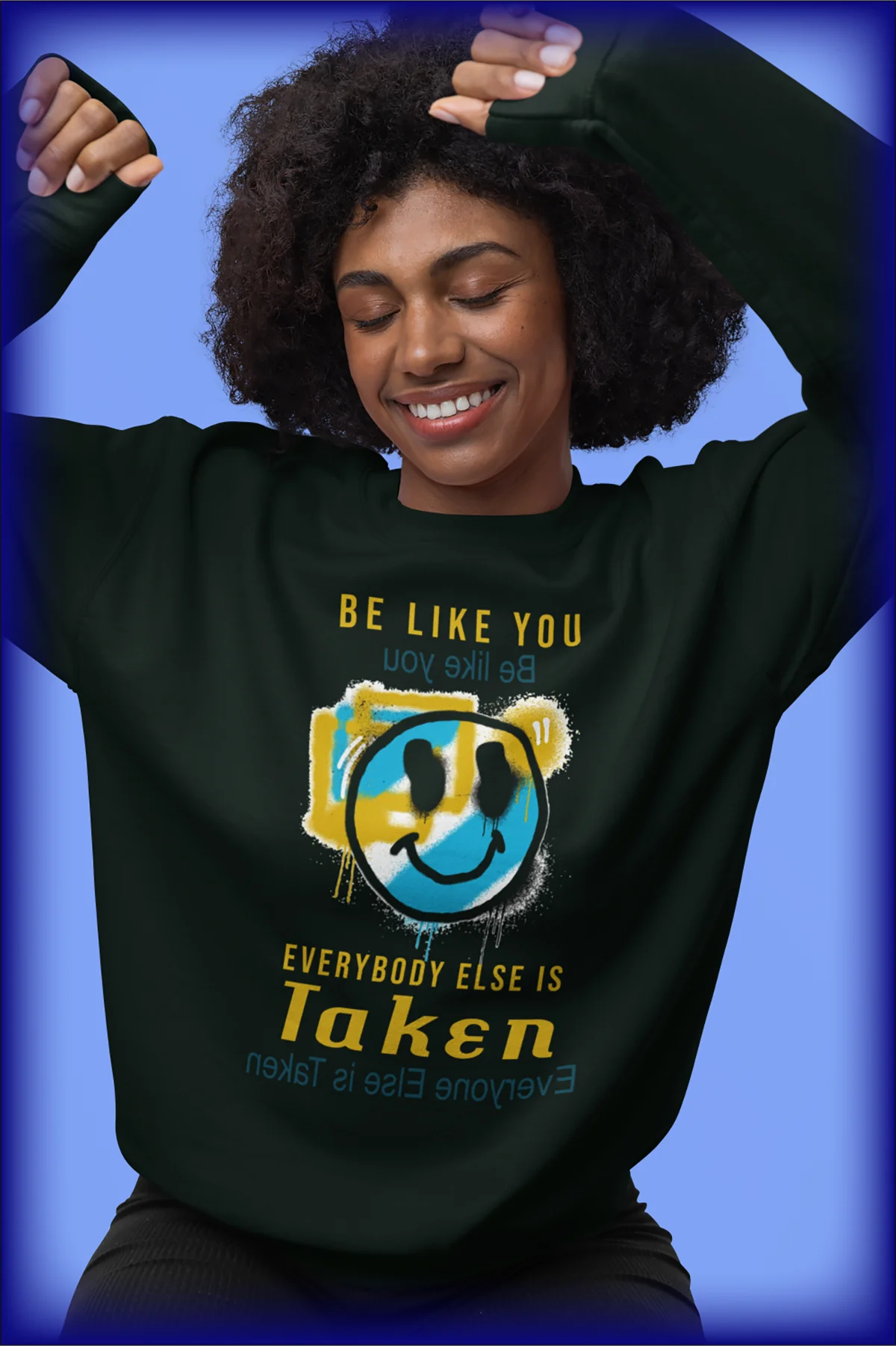 Person wearing a black sweatshirt with a graphic and text on a blue background